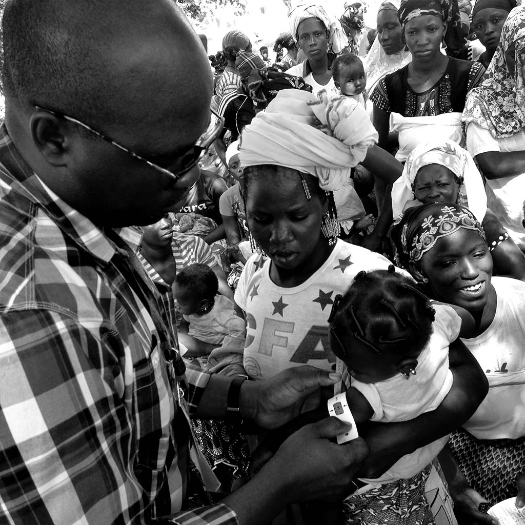 Doctor checking baby held by mother